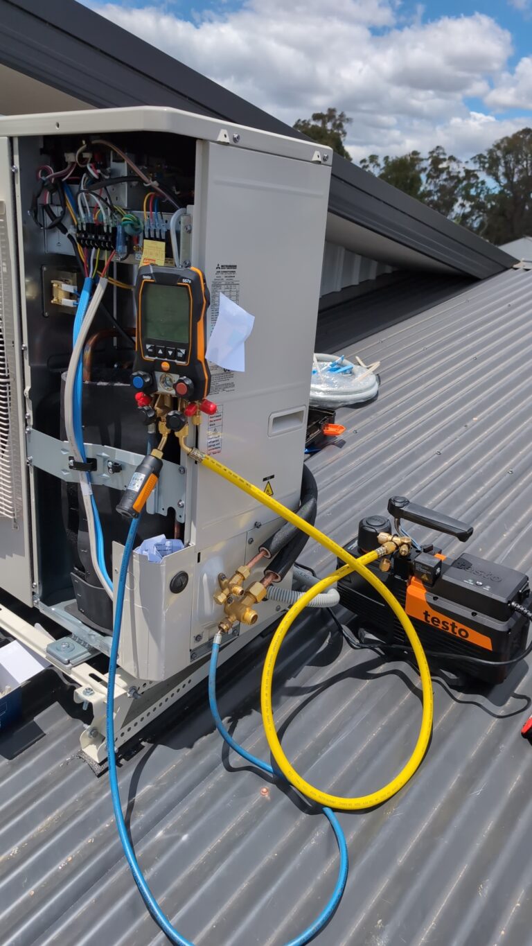 Rooftop AC unit under commissioning with Testo manifold and vacuum pump