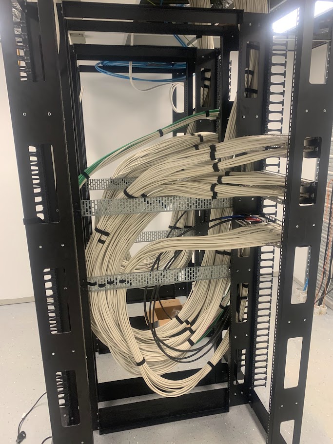 Professional structured cabling routed into an open data rack with tray support