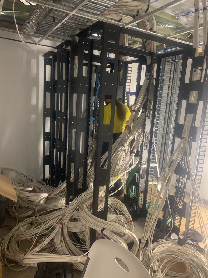 Technician managing large volume of data cabling during open rack installation