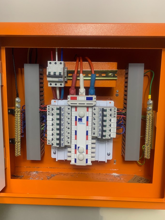 Commercial orange isolation switchboard with neatly organized three-phase cabling