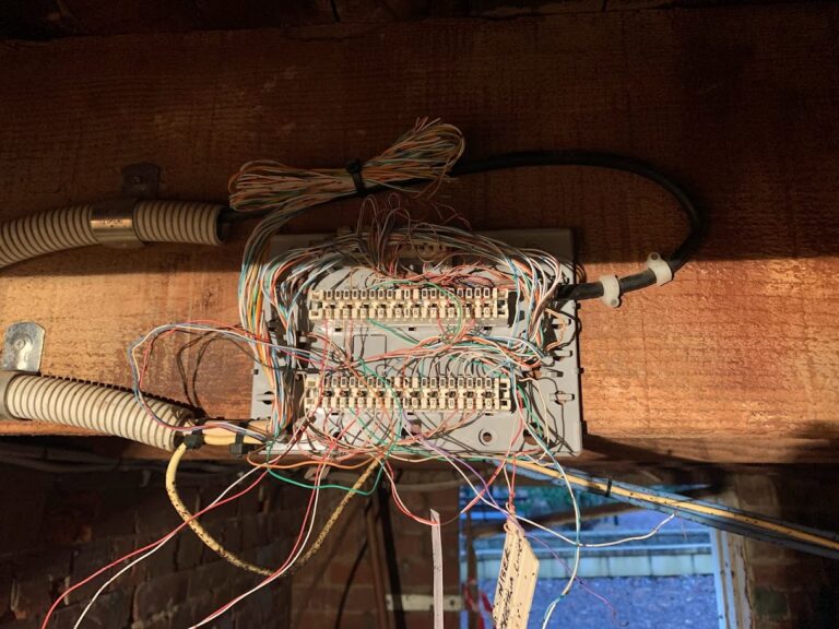 Legacy internal telephone frame with disorganised cabling on timber beam